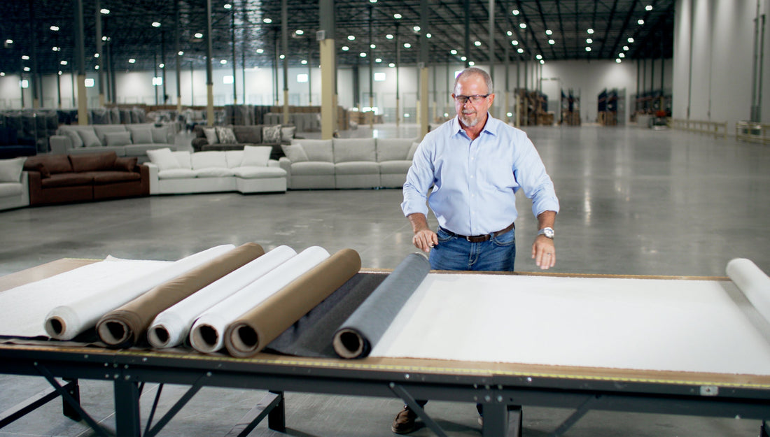 A man working with sofa fabric samples in a factory.